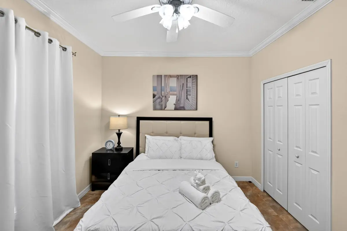 Bedroom with a bed, ceiling fan and double closet doors