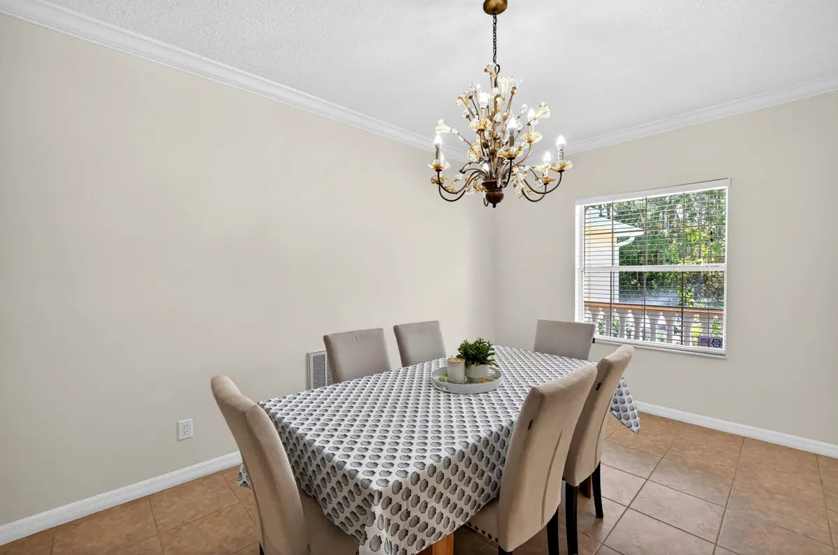 Dining table with upholstered chairs and a patterned tablecloth