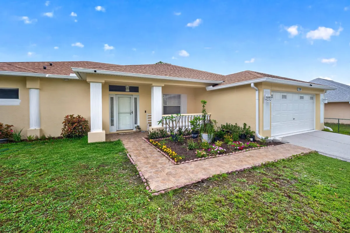 Front of the single-story home with a covered entry and landscaped walkway