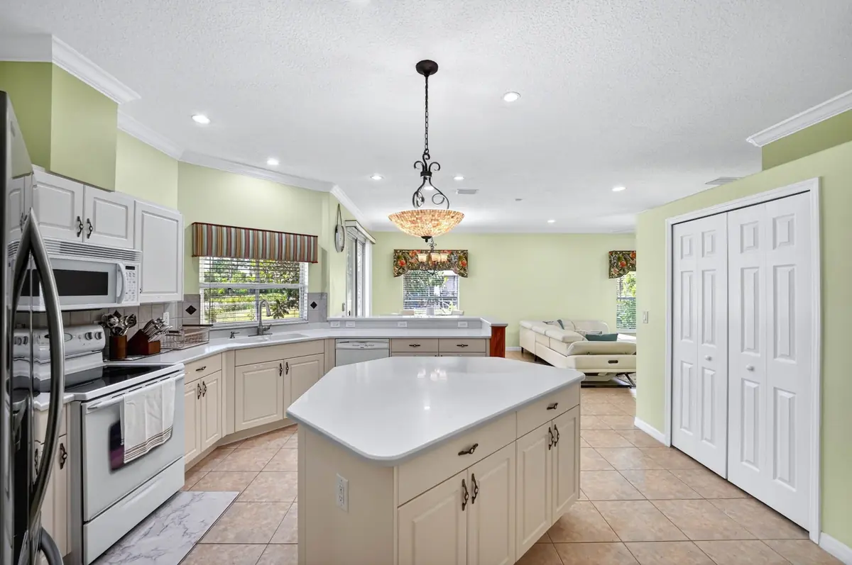 Wide view of the kitchen with an island and pantry doors